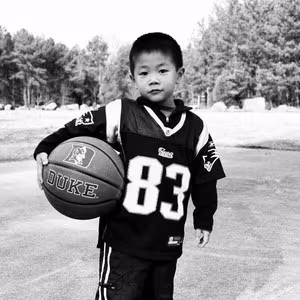 ADDICTED TO THE FIRE cover art - black and white photo of a kid holding a basketball
